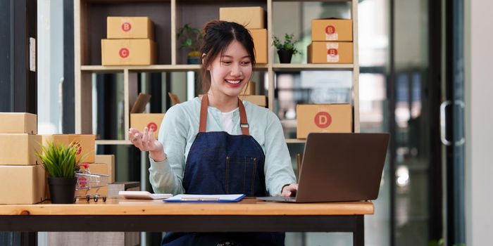 A portrait of Asian woman, e-commerce employee freelance with parcel box for deliver to customer. Online marketing packing box delivery concept