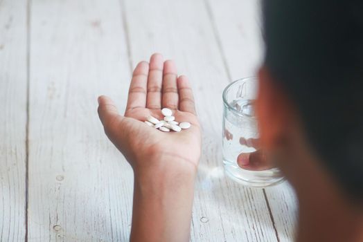 man's hand with pills spilled out of the container .