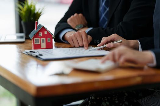 Close up Business woman or Real Estate agent explain signing agreement for buying house. Bank manager and real estate concept