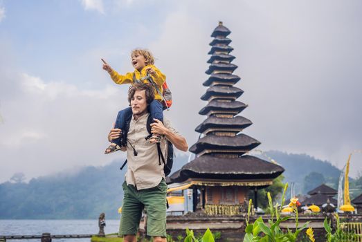 Dad and son in the background of Pura Ulun Danu Bratan, Bali. Hindu temple surrounded by flowers on Bratan lake, Bali. Major Shivaite water temple in Bali, Indonesia. Hindu temple. Traveling with children concept.