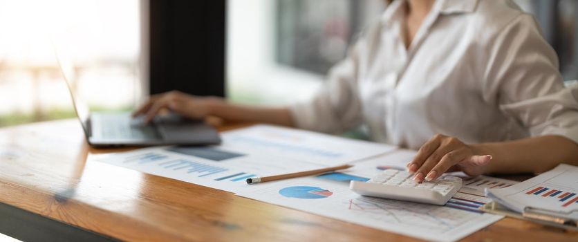 Businessman analyzing investment charts with calculator laptop. Accounting and technology in office.Business people using laptop at office,Analyze plans.