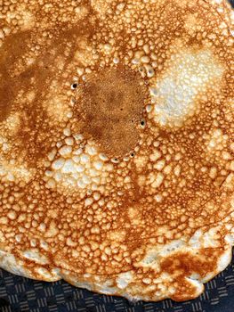 Making delicious openwork pancake on iron frying pan. Home cooking. Close-up top view.