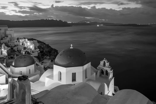 Oia town cityscape at Santorini island in Greece at sunset. Aegean sea in black and white