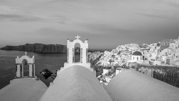 Oia town cityscape at Santorini island in Greece at sunset. Aegean sea in black and white