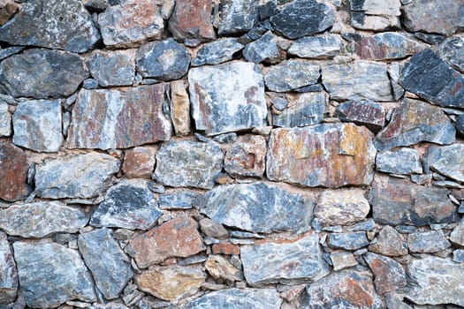 Texture of the masonry. Background of the surface of colored stones of uneven shape. Top view.
