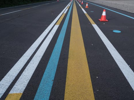 Various lines painted on asphalt. Yellow, blue, white. Part of a training ground for drivers.