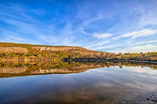 Fall foliage colors reflected in still lake water on a beautiful autumn day 