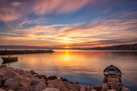 Stunning sunset on the bay with sun reflection and boats.