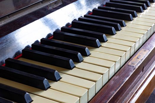 Close up of black and white keys of a vintage piano. Selective focus