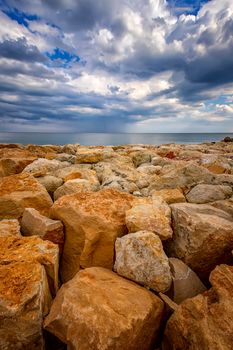 Beautiful stone shore seascape with colorful stones.  Vertical view