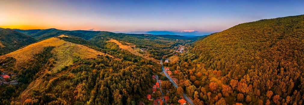 Panoramic Drone Aerial View view of mountain peaks and road between them. Autumn landscape