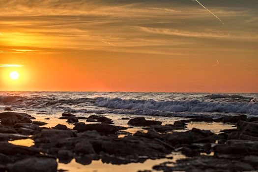 morning long exposure seascape with sun and stones on the water