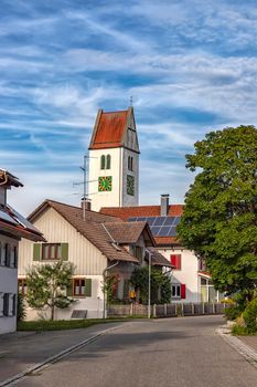 a small quiet street with houses and a clock tower in Leutkirch, Germany