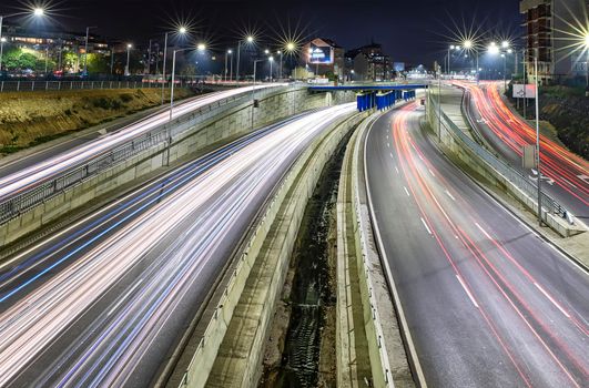 Stunning night traffic junction road with lights of vehicle movement.