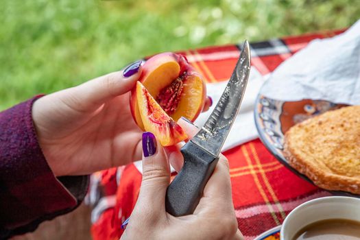 young girl eating peach on slices with her hands. Close up