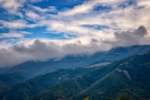 Beauty landscape of fog and clouds rolling over the forested mountain.