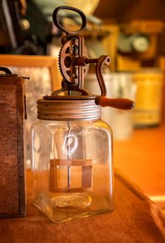 Vintage portable butter churn on the table. Vertical view