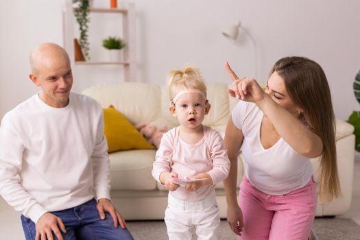 Cochlear implant on the child girl head and playing with mother and father. Hearing aid and deafness and innovative health technology