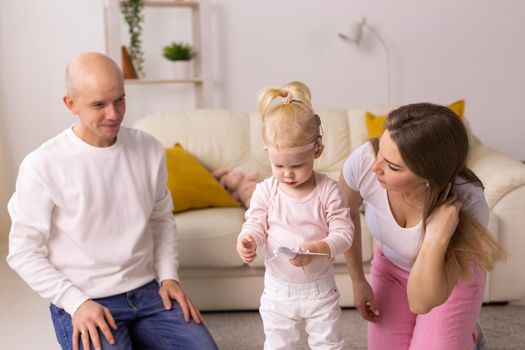 Cochlear implant on the child girl head and playing with mother and father. Hearing aid and deafness and innovative health technology