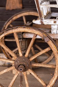 old wooden wheels are on the carriage at the ranch.