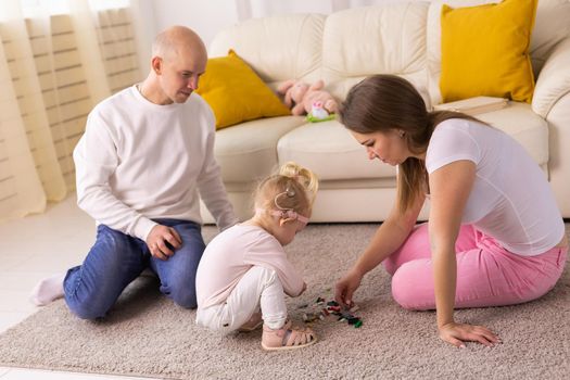 Cochlear implant on the child girl head and playing with mother and father. Hearing aid and deafness and innovative health technology