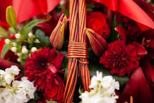 Flowers on memorial. Details of funeral decoration. Bouquet of flowers on grave. Mourning ceremony.