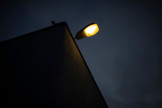 Lamp on roof of building. Light on house. Street lighting. Lamp against sky.