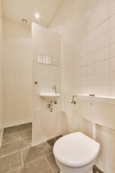 Modern flush toilet and ceramic sink installed on white tiled walls near mirror and towel in small restroom at home