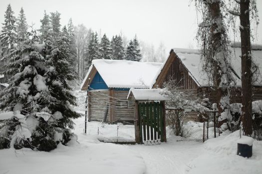 Country house in winter. Roof is in snow. Countryside. Snowy winter in Russia.