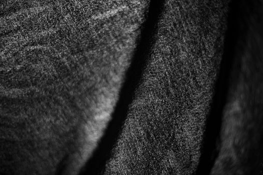 Fabric on lumen. Black thin fabric on window. Light through curtains. Texture of dark material.