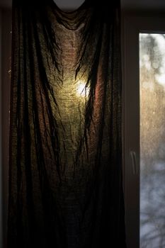 Curtain on window in morning. Dawn outside window. Fabric closes from light.