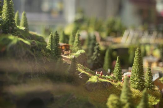 Town in mountains in miniature. Trees made of plastic. Toy land. Game world.