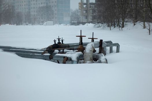 Pipes in winter in city. Sewer unit. Heating equipment.