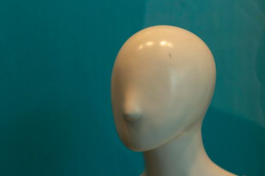 The face of the mannequin without details. Plastic head to show clothes. Mannequin with nose. The absence of eyes and ears on the head of the sculpture.