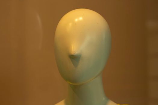 The face of the mannequin without details. Plastic head to show clothes. Mannequin with nose. The absence of eyes and ears on the head of the sculpture.