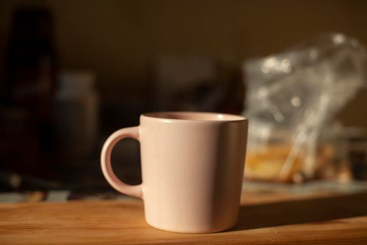 Cup on table. Kitchen details. Light on dishes. Morning drink. Tea for breakfast.