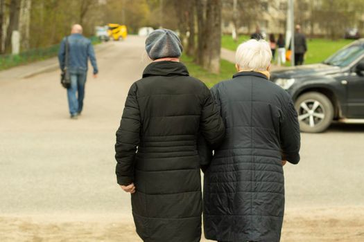 Pensioners in Russia. Women walk down the street. Grandmothers walk down the road. People on the street of Moscow.