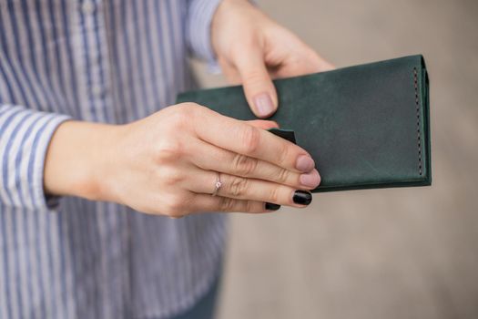 Sky blue handbag purse and beautiful woman hand with manicure. blurred background