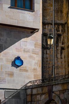 Public street sign on a wall on the streets of Guernica, Basque Country, Spain. Name labelling square Elai-Alai Plaza. Tourism in Europe, north of Spain. Vertical shot