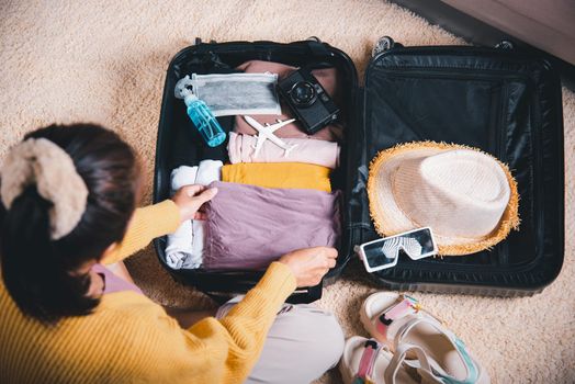 Preparing for travel in new normal. Woman packing clothes in luggage for new journey, Preparation travel suitcase at home, Travel vacation traveling after quarantine coronavirus pandemic concept