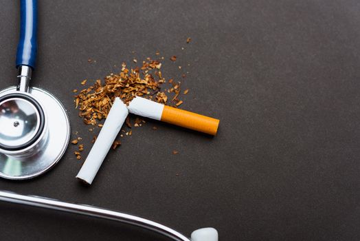 31 May of World No Tobacco Day, no smoking, close up of broken pile cigarette or tobacco and doctor stethoscope on black background with copy space, and Warning lung health concept