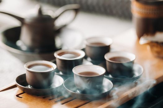 Cups with poured tea before the tea ceremony with incense.