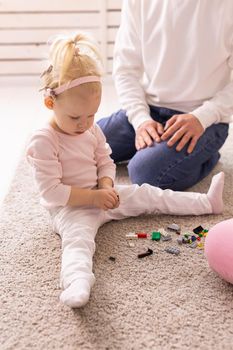 Baby with cochlear implants playing with her mother and father at home.