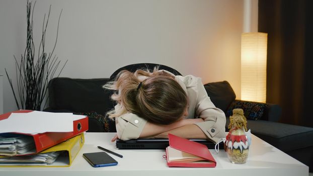 Sad Caucasian business woman girl after hard day work project sits in office needs a sleep and rest.