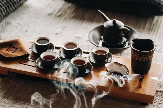 Tea ceremony with smoking incense. Incense stick and tea ceremony.