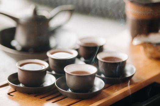 Cups with poured tea before the tea ceremony with incense.