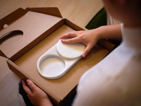 an entrepreneurial girl shows her product in a coworking space, top view