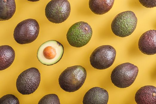 avocado whole and half on yellow background. High quality photo