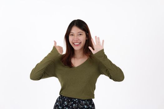 Image of happy young girl standing and Looking camera pointing isolated over white background