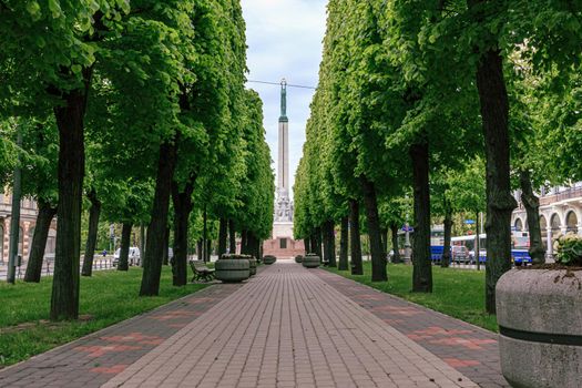 Riga, Latvia: June 1, 2020: the monument of freedom, standing women with tree stars in hands, perspective view from city street park